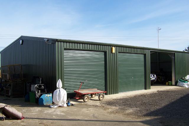 A dark green building with multiple roller doors